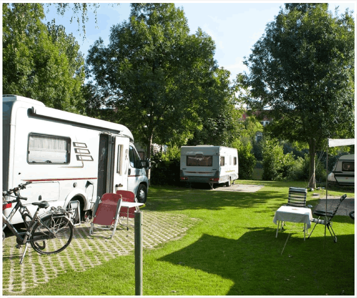 A couple of rvs parked in the grass.