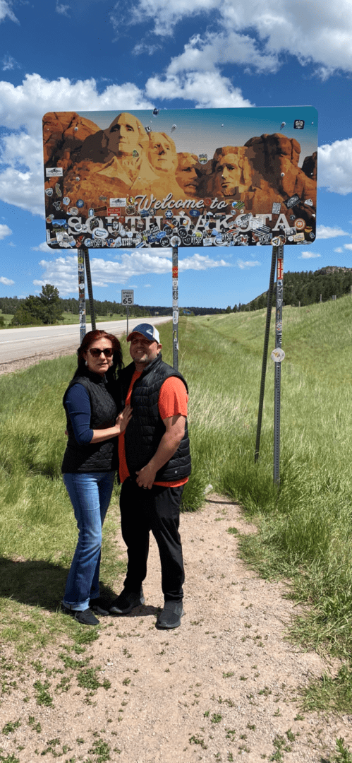 A man and woman standing under a sign.