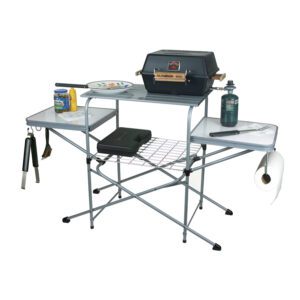 A folding table with grill and bbq on top.