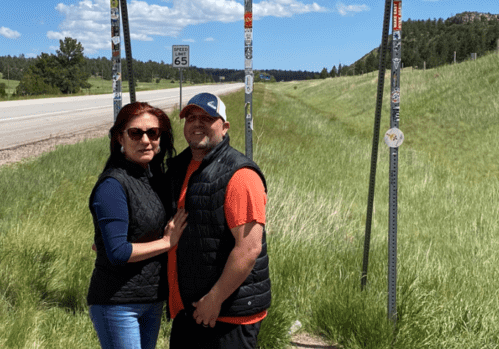 A man and woman standing under a sign.